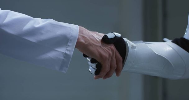 Man and robot shaking hands - Фото, изображение