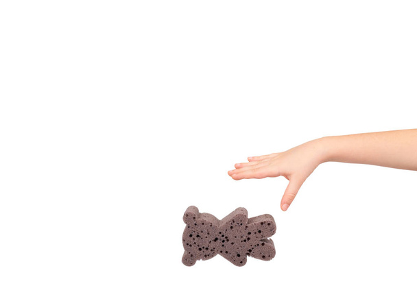 Kids hand with bathroom sponge, soft foam for body care. - Foto, afbeelding