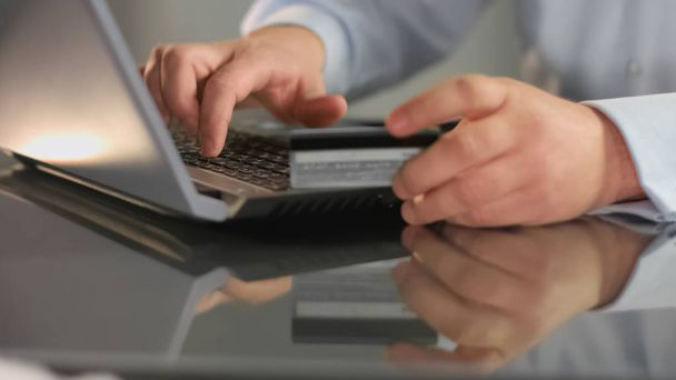 Businessman entering credit card number laptop, online banking service, booking - Фото, зображення