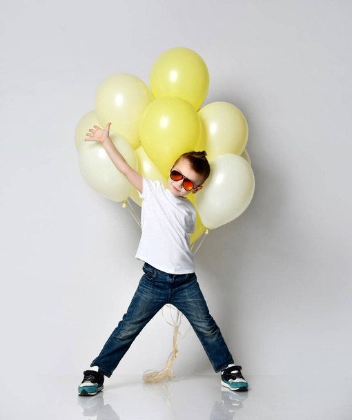 Cute kid holding a lot of balloons - Foto, Imagen