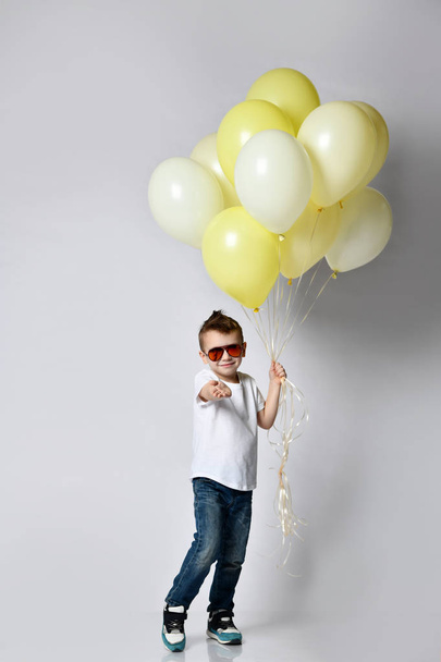 Lindo niño sosteniendo una gran cantidad de globos - Foto, Imagen