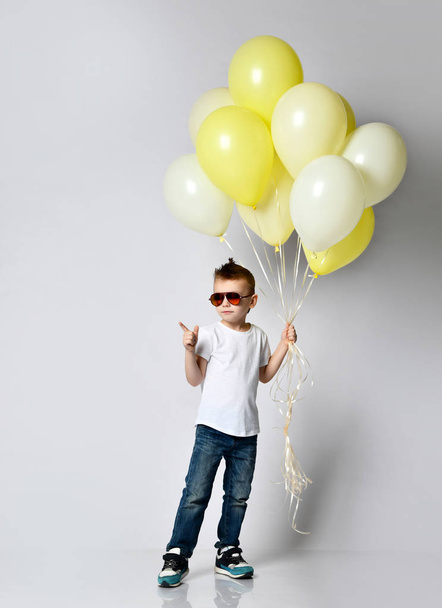 Cute kid holding a lot of balloons - 写真・画像