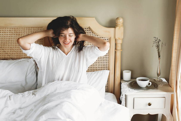 Beautiful happy young woman lying on bed in the morning in hotel - Photo, Image
