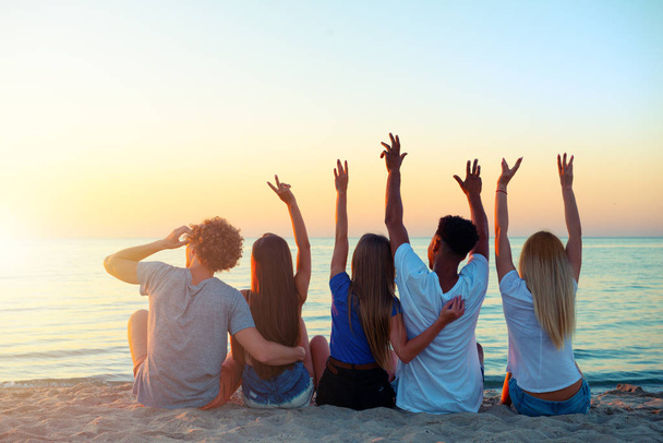 Gruppo di amici felici che si divertono sulla spiaggia dell'oceano all'alba
 - Foto, immagini