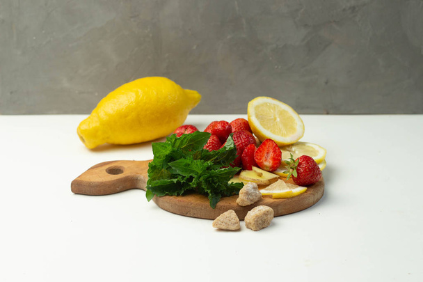Set de Mojito: limón, higo, menta y fresa en una tabla de cortar de madera
 - Foto, imagen
