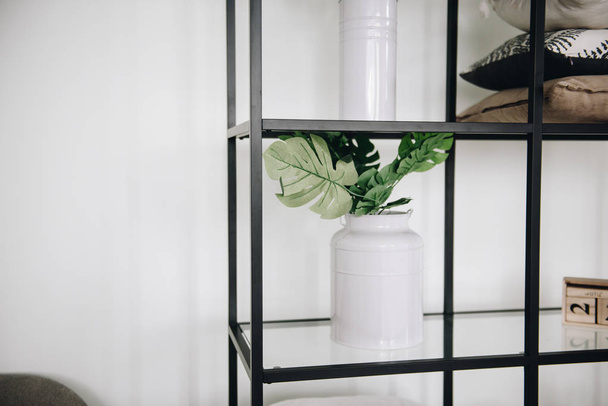 Modern potted evergreen artificial plants used in interior decoration on a shelf - Foto, imagen