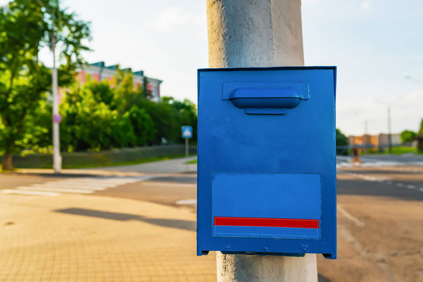 Синя поштова скринька на сірому посту
 - Фото, зображення