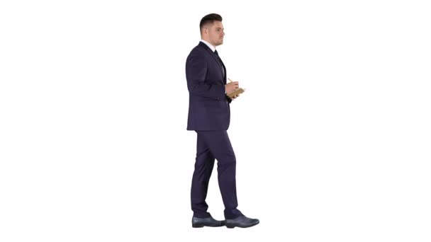 Jonge positieve Kaukasische zakenman wandelen en het maken van checklist op witte achtergrond. - Video