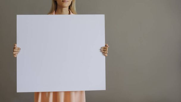 A pretty blonde girl with a whiteboard - Фото, изображение