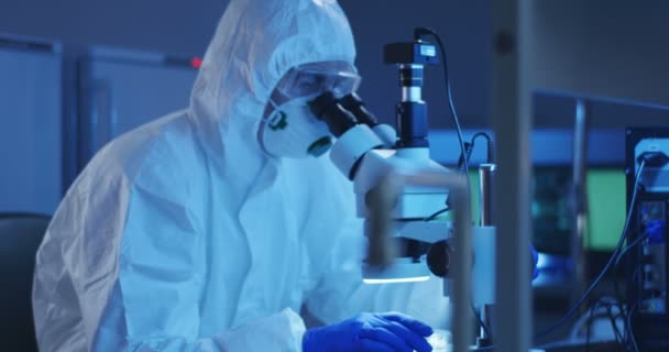 Científico examinando la muestra con un microscopio
 - Imágenes, Vídeo