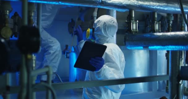 Scientists in hazmat suit conducting maintenance - Footage, Video