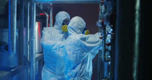 Scientists in hazmat suits checking equipment - Footage, Video
