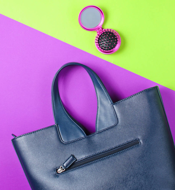 Women's accessories. Leather bag, comb-mirror on a two-color paper background. Top view - Photo, Image
