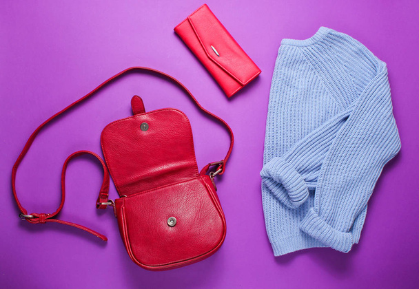 Women's fashion items on a purple background. Sweater, leather bag, red purse. Top view - Photo, Image