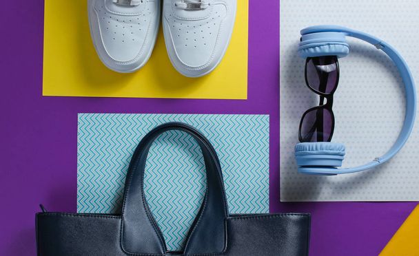 Moderne accessoires op een creatieve kleur achtergrond. Witte Sneakers, tas, koptelefoon, zonnebril. Objecten. Bovenaanzicht, vlakke lay - Foto, afbeelding
