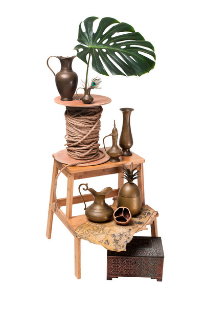 Vase en cuivre avec carte du trésor et des feuilles Monstera
 - Photo, image