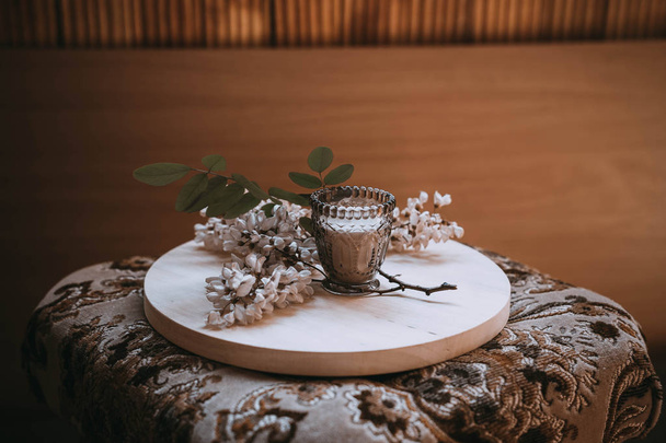 κλαδί γιασεμί σε μια ξύλινη πλάκα δίπλα σε ένα κερί - Φωτογραφία, εικόνα
