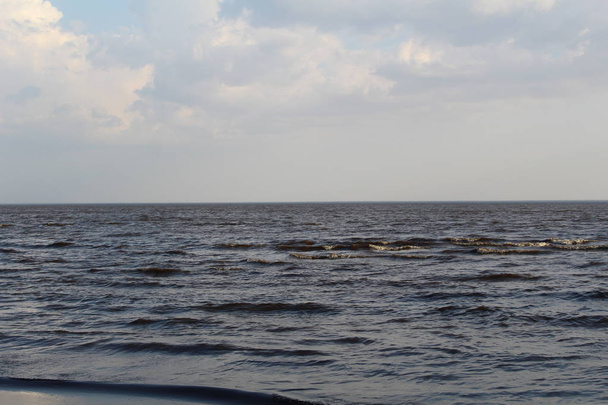 Beyaz göl. Baharda dalgalar ve mavi gökyüzü. Beyaz Göl 'ün fotoğrafı. Spreing zamanının büyük mavi dalgaları üzerinde. Gökyüzü beyaz bulutlarla mavidir. Güneşli hava. Rusya 'nın Vologda bölgesindeki güzel beyaz göl.. - Fotoğraf, Görsel