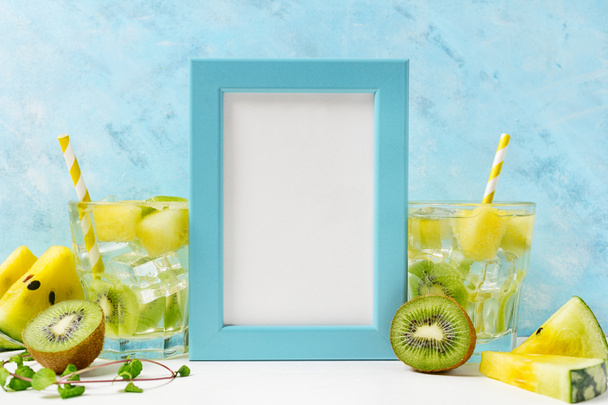 blue Photo frame mockup: cool and fresh kiwi watermelon lemonade with ingredients on blue background. Vegetarian food, healthy lifestyle concept. Summer specials tamplate. Detox - Foto, immagini