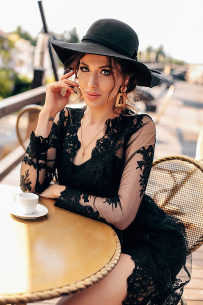 beautiful sexy woman with dark hair in elegant black dress and h - Zdjęcie, obraz
