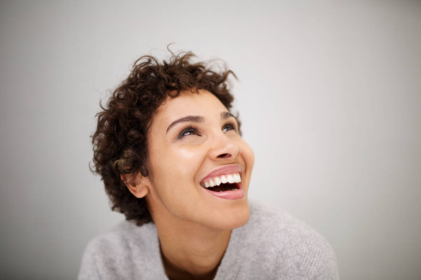 Gros plan portrait de heureuse jeune femme afro-américaine riant et levant les yeux
 - Photo, image