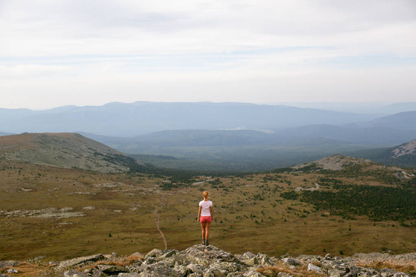 Tourist girl traveler admiring the view of the mountains - Foto, Imagen