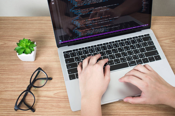 As mãos dos programadores estão criando código na tela do laptop
. - Foto, Imagem