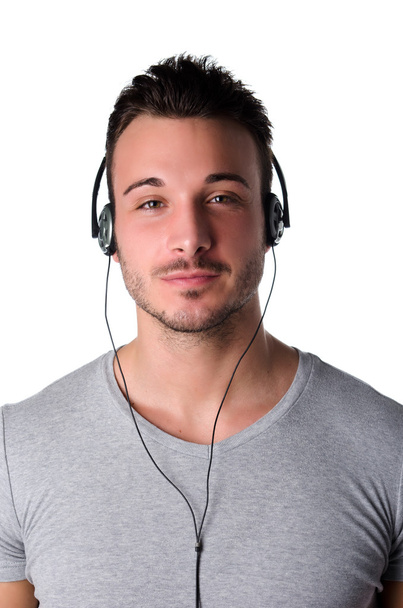 Attractive smiling young man listening to music with headphones - Foto, Imagem