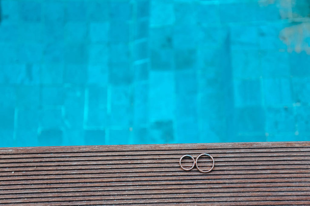 Nahaufnahme von goldenen Eheringen und Pool - Foto, Bild