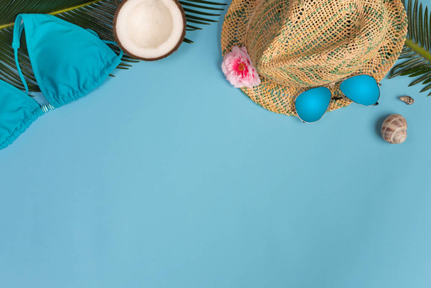 Creative Flat lay fashion style with cosmetic, sunglasses, palm leaves and panama hat on pastel color background - 写真・画像
