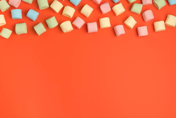 Levend koraal, kleur van het jaar 2019. Mini marshmallows op trendy pastel koraal achtergrond. Platte lay, kopieer ruimte - Foto, afbeelding