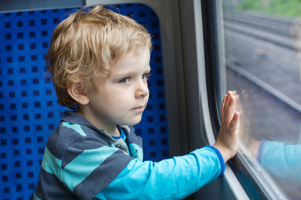 Lindo niño mirando por la ventana del tren
 - Foto, Imagen