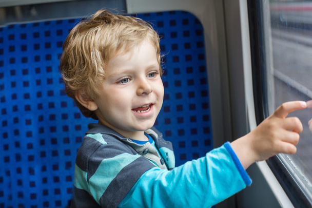 Bonito menino olhando para fora da janela do trem
 - Foto, Imagem