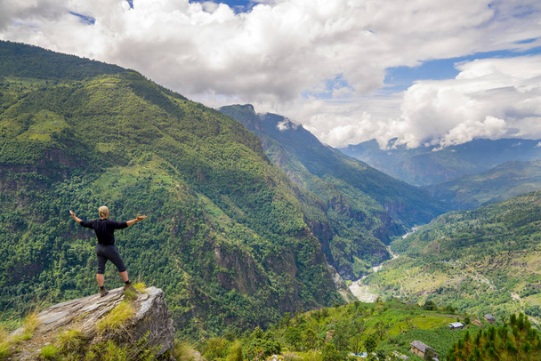 Homem em pé no topo da colina no Himalaia
 - Foto, Imagem