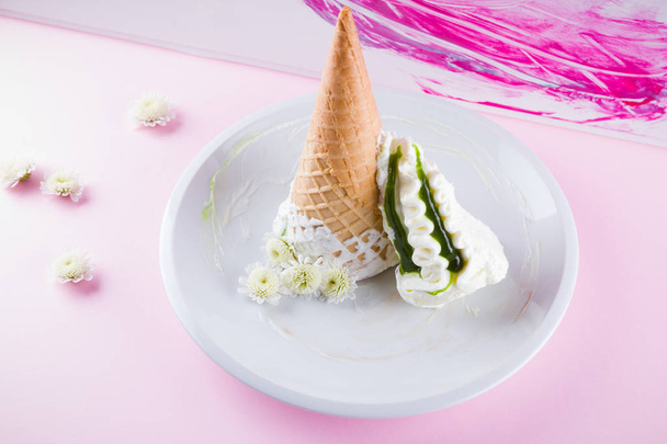 ピンクの背景にアイスクリームコーンと白い花、夏のコンセプト。白いプレートにジャムのデザート。パステルカラーのアイスクリームとワッフルコーン。スペースのコピー - 写真・画像