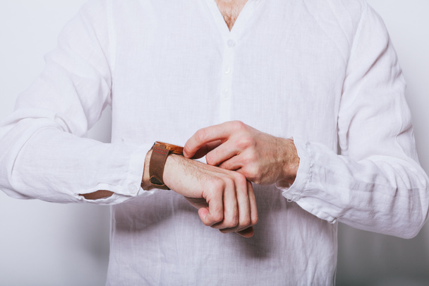 Un uomo in un'elegante camicia bianca con un orologio sulla mano
 - Foto, immagini