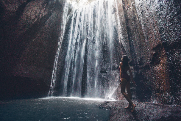 Junge Frau im Badeanzug in der Nähe eines Wasserfalls Tukad Cepung Bali Indonesien - Foto, Bild
