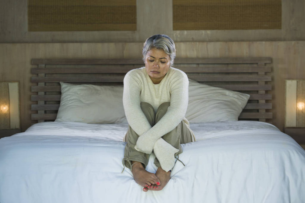 depressed and sad grey hair mature woman crying lonely sitting on bed suffering crisis in pain and depression problem feeling lost and overwhelmed at home - Foto, Imagen