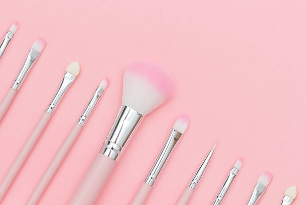 Set of pink makeup brushes on pastel pink background. Top-down composition, copy space - Photo, Image