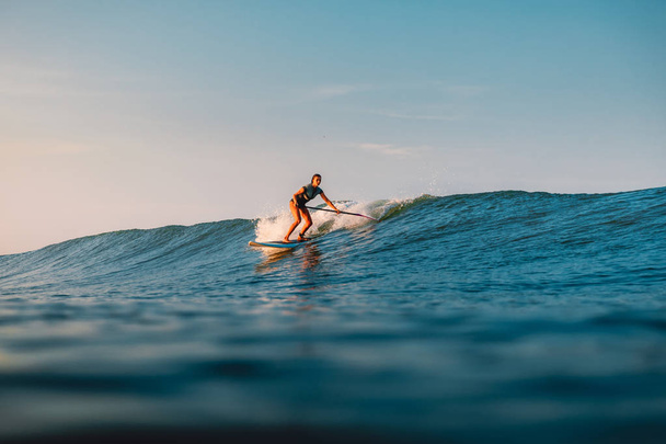 April 12, 2019. Bali, Indonesia. Stand Up Paddle surfer ride on ocean wave. Stand Up Paddle surfing at waves in Bali - Valokuva, kuva