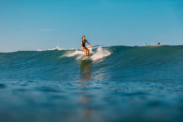 April 12, 2019. Bali, Indonesia. Stand Up Paddle surfer ride on ocean wave. Stand Up Paddle surfing at waves in Bali - Photo, Image