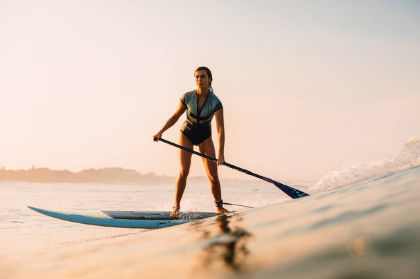 12. april 2019. bali, indonesien. Stand Up Paddle Surfer Fahrt auf der Ozeanwelle. Stand Up Paddle Surfen auf Wellen in Bali - Foto, Bild