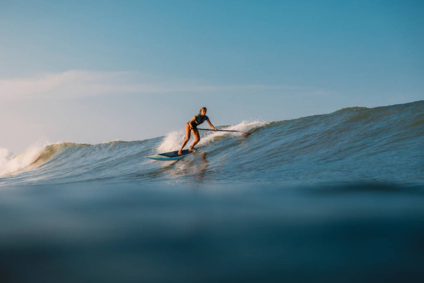 12. dubna 2019. Bali, Indonésie. Stoupni si surferův výlet na oceánskou vlnu. Vstát a surfovat po vlnách na Bali - Fotografie, Obrázek