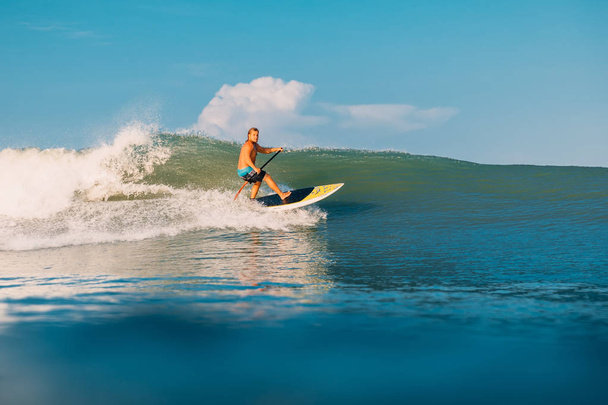 12 de abril de 2019. Bali, Indonésia. Stand Up Paddle surfista passeio na onda do oceano. Stand Up Paddle surfando em ondas em Bali
 - Foto, Imagem
