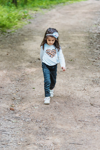 menina caminha em uma estrada rural no parque
 - Foto, Imagem