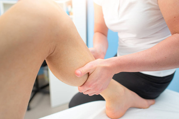 Massophysiotherapy treatment in the calf of a sportsman - 写真・画像