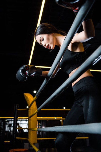 alacsony látószögű kilátás sportos nő bokszkesztyűk álló tornaterem - Fotó, kép