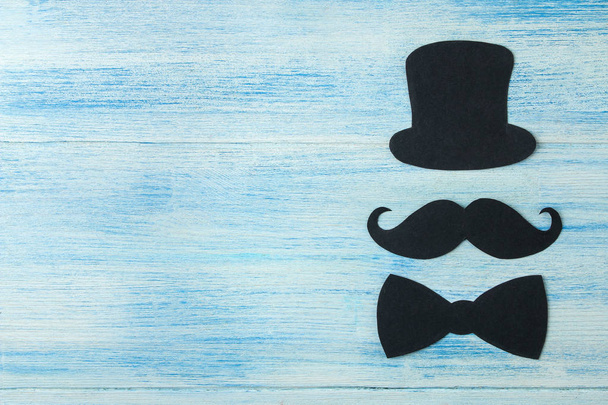 Buona festa del papà. baffi da uomo decorativi, cappello e papillon su uno sfondo di legno azzurro. vista dall'alto
 - Foto, immagini