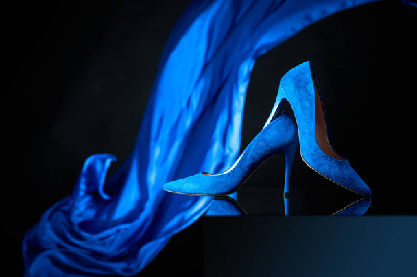 Синяя женская вельветовая обувь на черном фоне
. - Фото, изображение