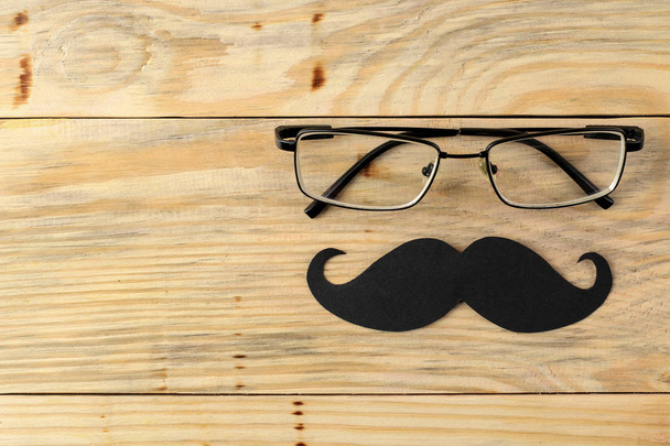 Feliz día del padre. bigote de los hombres decorativos y gafas sobre un fondo de madera natural. vista superior
 - Foto, imagen